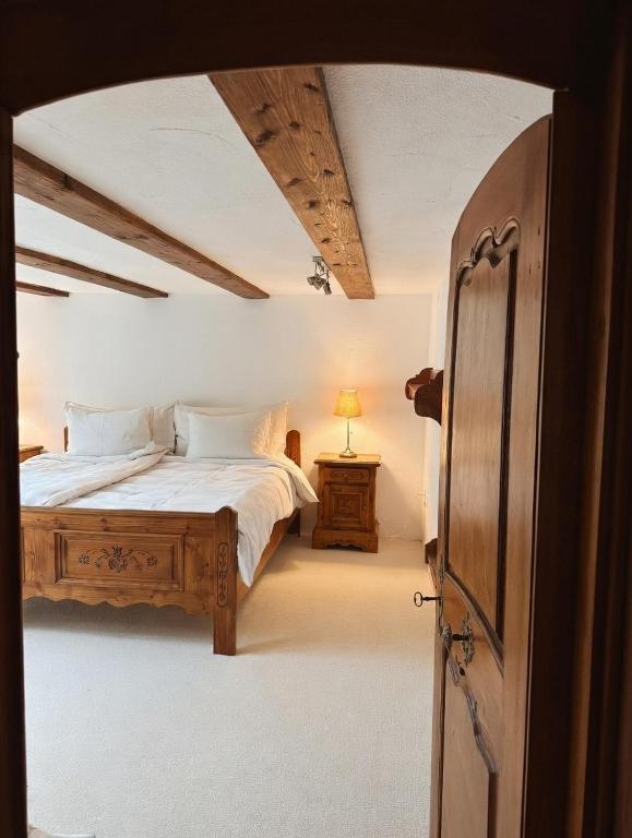 a bedroom with a bed with white sheets and a table at Panoramic apartment with charming swiss interior in Wädenswil