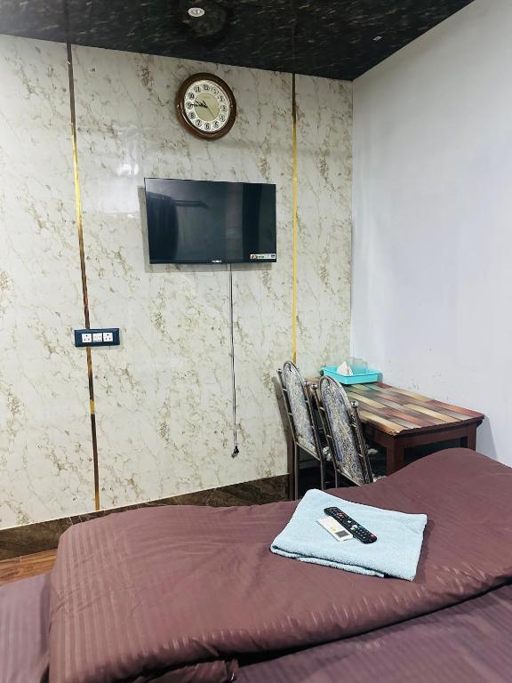 a bedroom with a bed and a table and a clock at Hidden key guest house in Bhubaneshwar