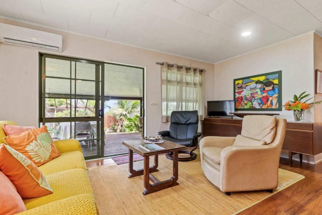 a living room with a couch and chairs and a table at Peaceful 2BR Garden Bungalow in Taravao