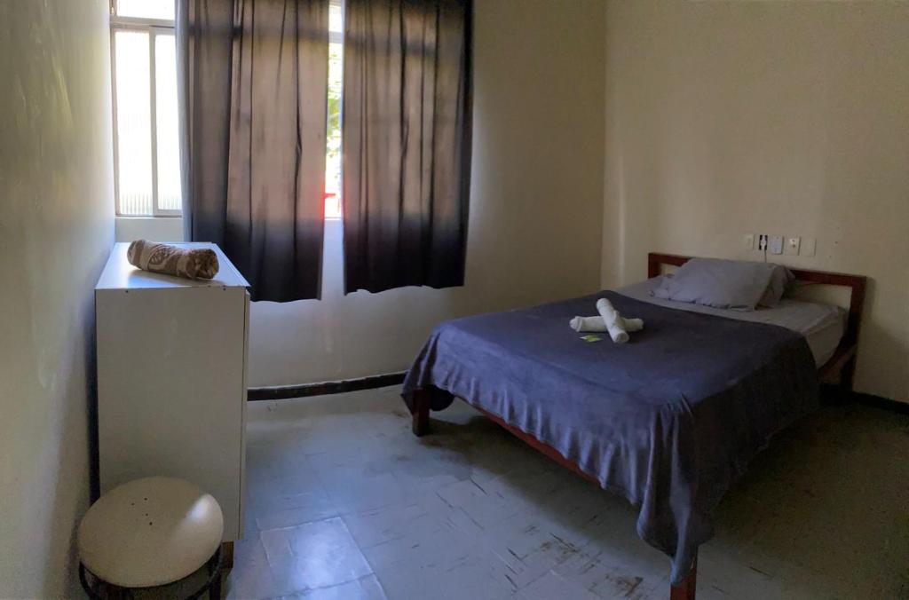 a small bedroom with a bed and a window at Hotel no centro in Sete Lagoas