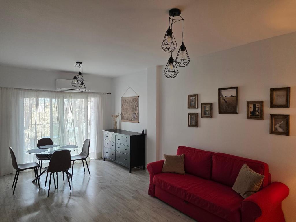 a living room with a red couch and a table at Beach apartments in Limassol