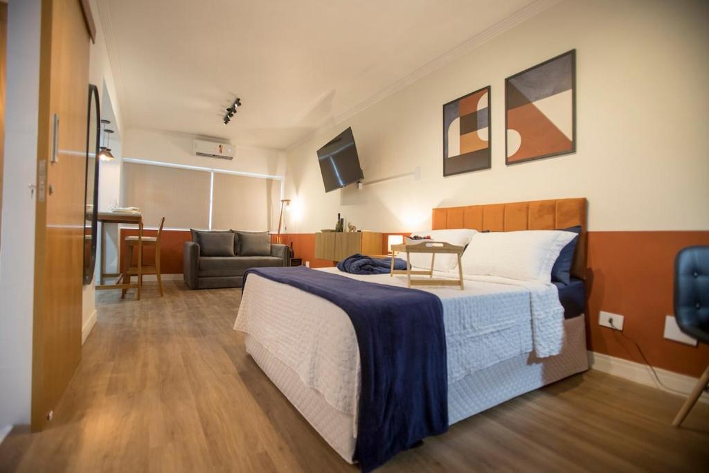 a bedroom with a bed and a living room at ApêBrisa73 in São Vicente