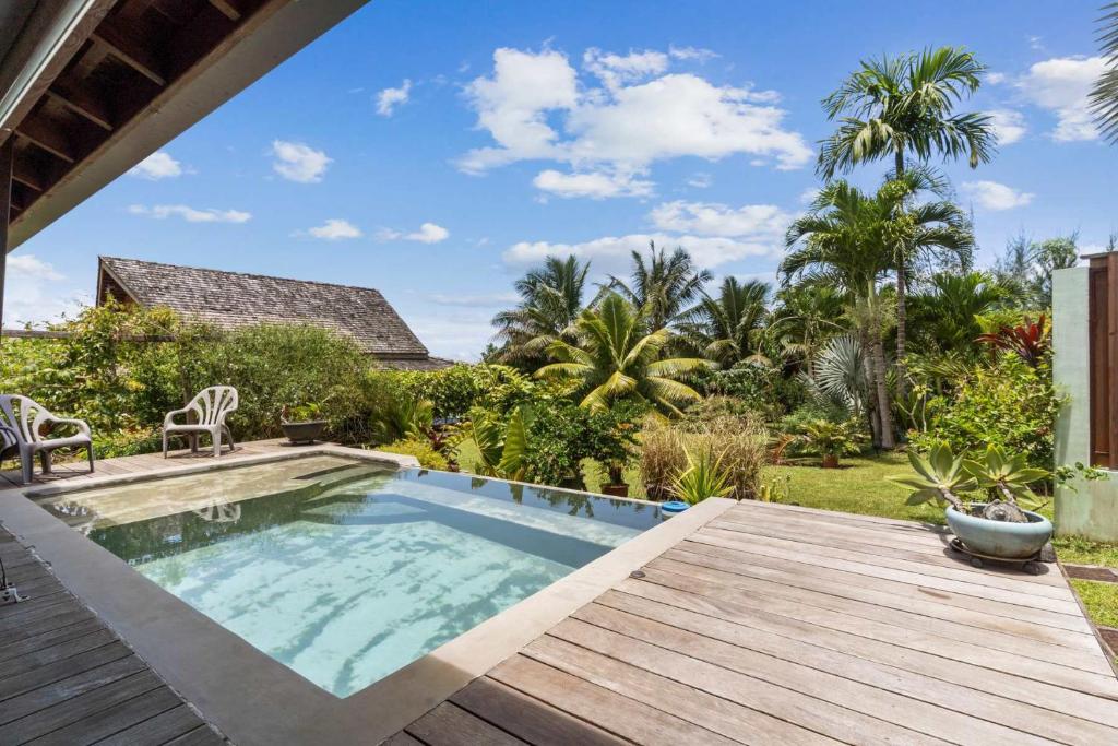 a swimming pool with a wooden deck and a backyard at Charming Tropical Retreat with Private Pool in Taravao