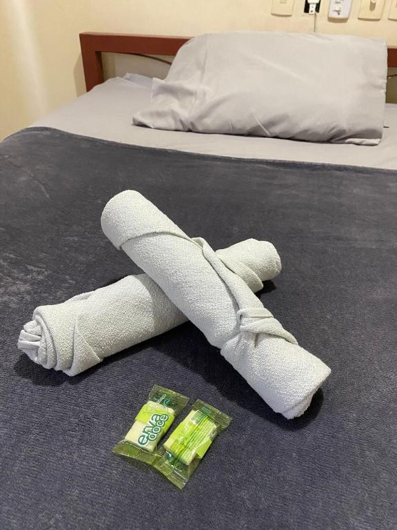 an injured leg with a cast on a bed at Hotel econômico in Sete Lagoas