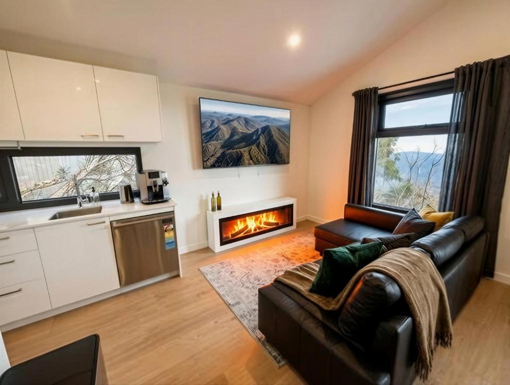 a living room with a couch and a fireplace at Mount Buller Alpine Chalet Mountain Views Sleeps up to 12 in Mount Buller