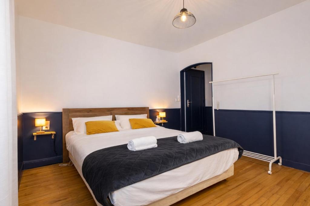 a bedroom with a large bed with two towels on it at Une Maison en centre ville in Cholet
