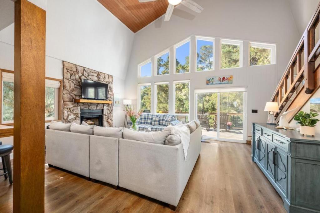 a living room with a white couch and a fireplace at Forest Home with Deck, EV Station, King Beds in Cambria
