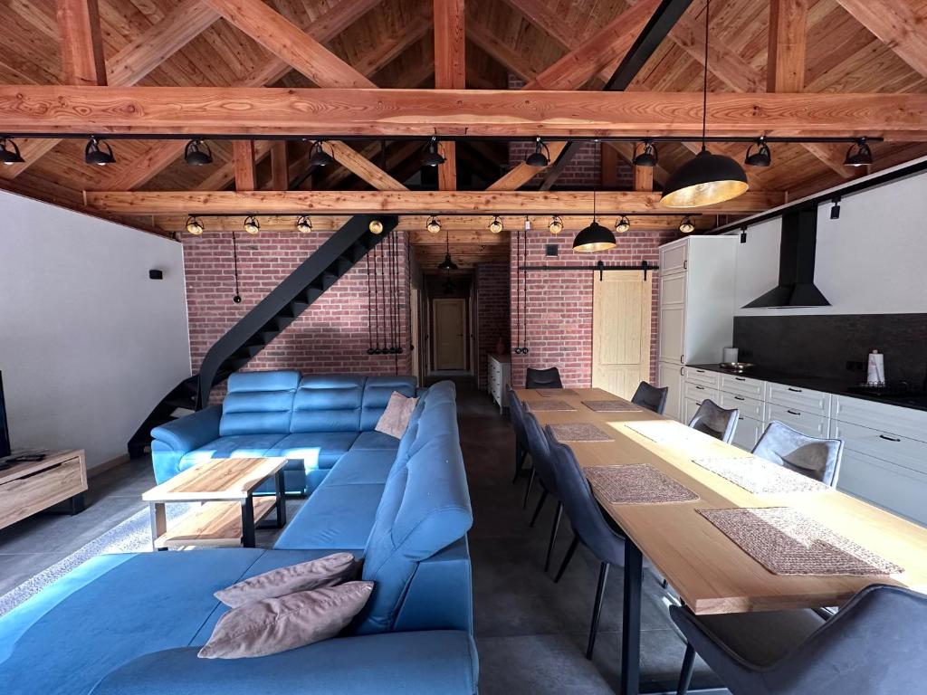 a dining room with a long table and blue couch at Dom pod Aniołem in Sierakowice Prawe