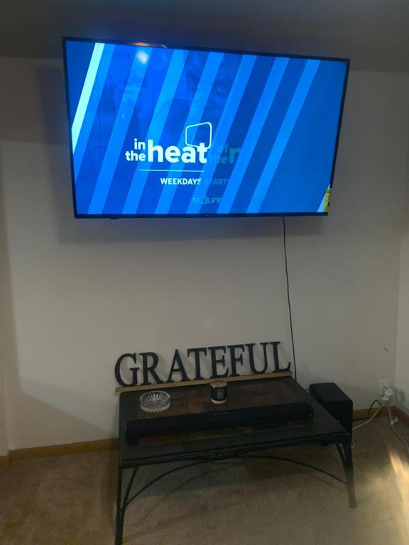a flat screen tv hanging on a wall with a bench at The Upper Room in Milwaukee