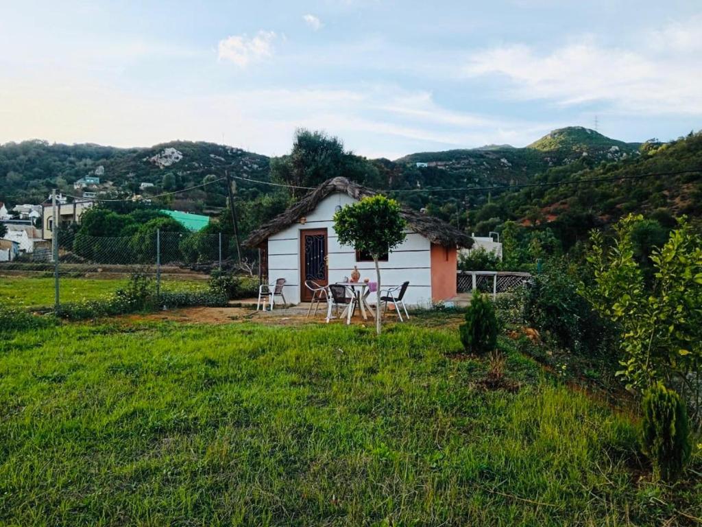 ein kleines Haus mit Tisch und Stühlen auf einem Feld in der Unterkunft LuxeCabane in Kouf el Fouki