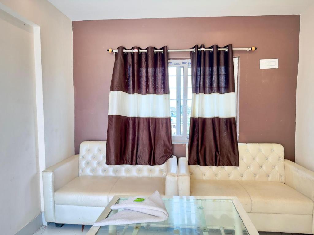 a living room with a couch and a window at BN Hotel in kolkata