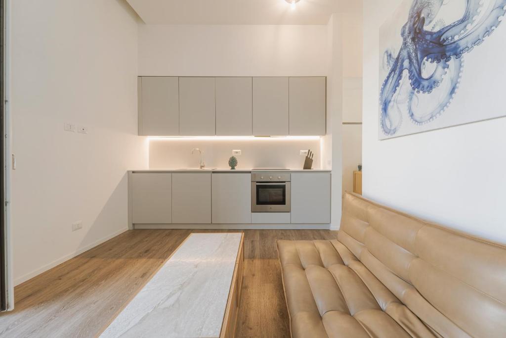 a kitchen with a couch in the middle of a room at Dimora del Polpo - Centro Storico in Trapani