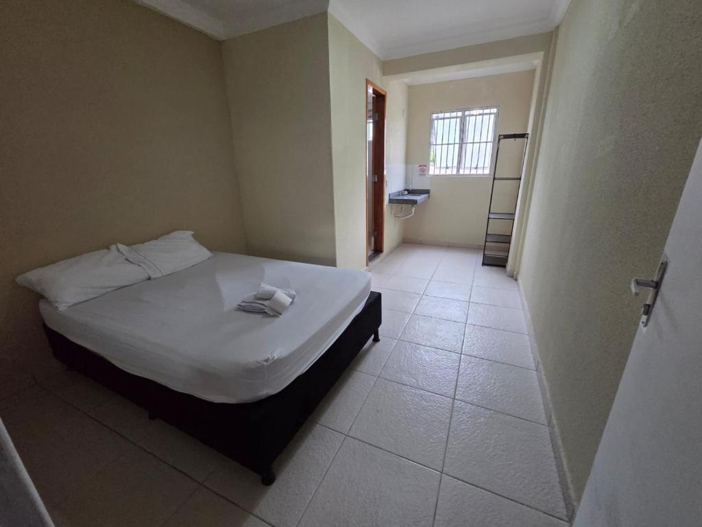 a bedroom with a bed and a tiled floor at Hostel Araguaia in Goiânia