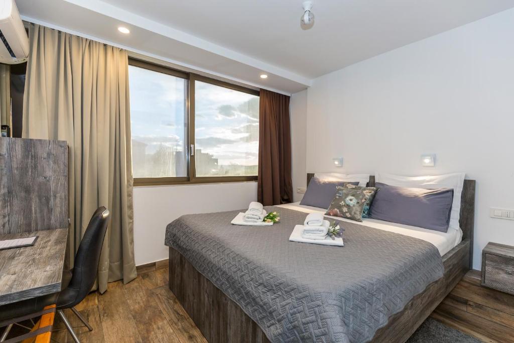 a hotel room with a bed and a window at Apinelo Rooms in Split