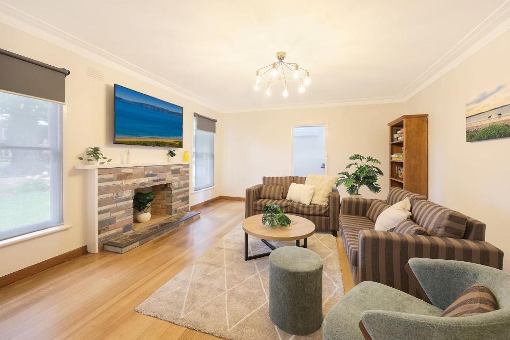 a living room with couches and a fireplace at Jack & Bias Cottage in Warrnambool