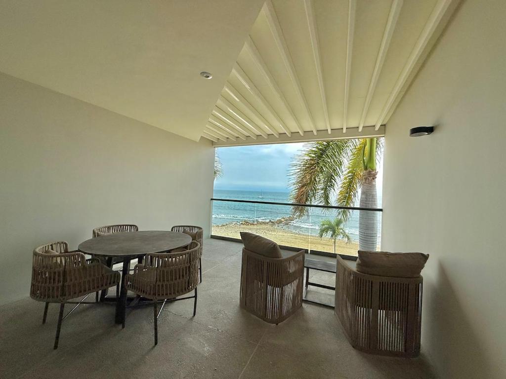 a dining room with a table and chairs and a view of the beach at Zantamar TH06B, oceanfront in Cruz de Huanacaxtle