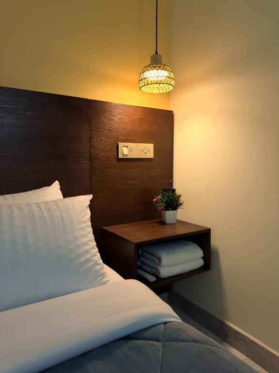a bedroom with a bed and a table with a potted plant at KLEINN HOTEL BOGOTÁ in Bogotá
