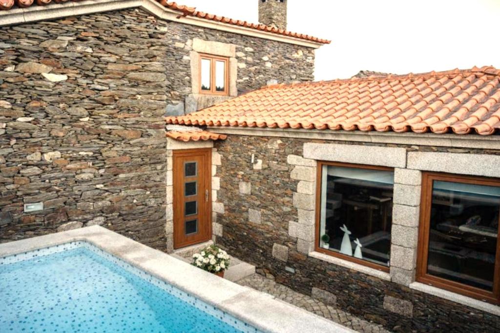 a house with a swimming pool in front of a building at Casa da Ferreira_Vila Real in Vila Real