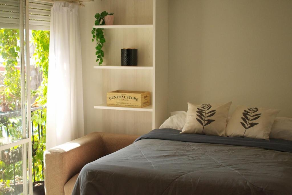 a bedroom with a bed and a window with a box at Destino Güemes Cozy Studio in Mar del Plata