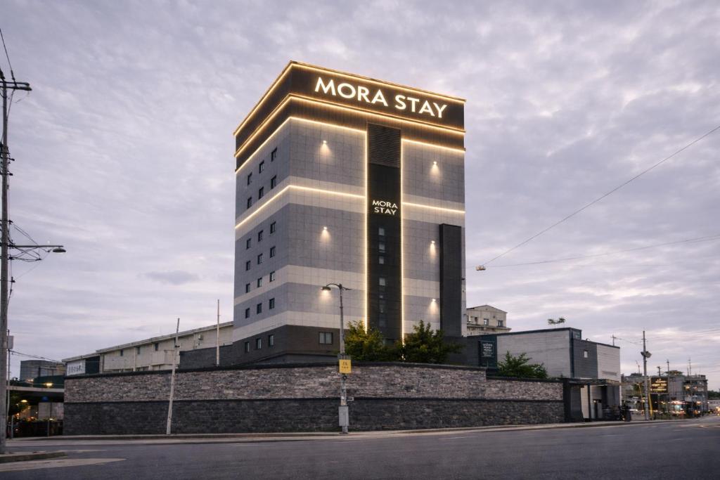 a large building with a sign that reads mora stay at Mora Stay in Busan