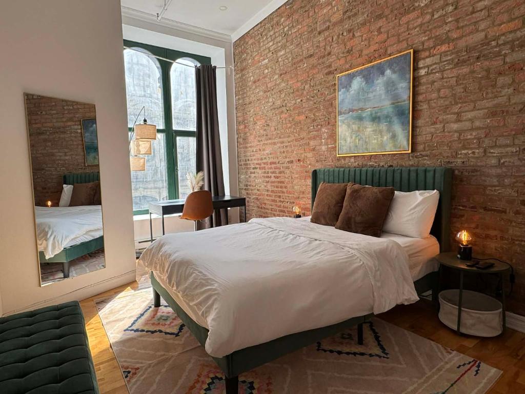 a bedroom with a bed and a brick wall at Top Location - The 777 Old Port Gem in Montreal