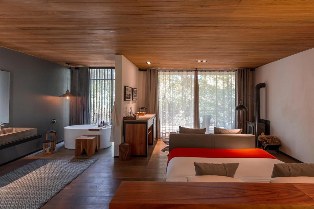 a bedroom with a large bed and a bathroom at Rodavento Valle de Bravo in Valle de Bravo