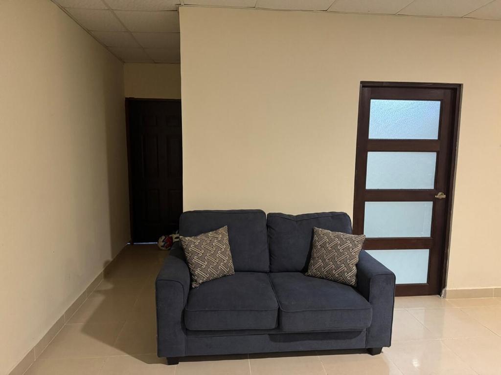 a blue couch sitting in a room with a door at Fourth Studio and Festivities in Guararé