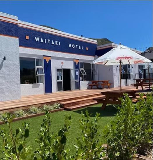 a building with a picnic table and an umbrella at Waitaki Hotel Kurow in Kurow