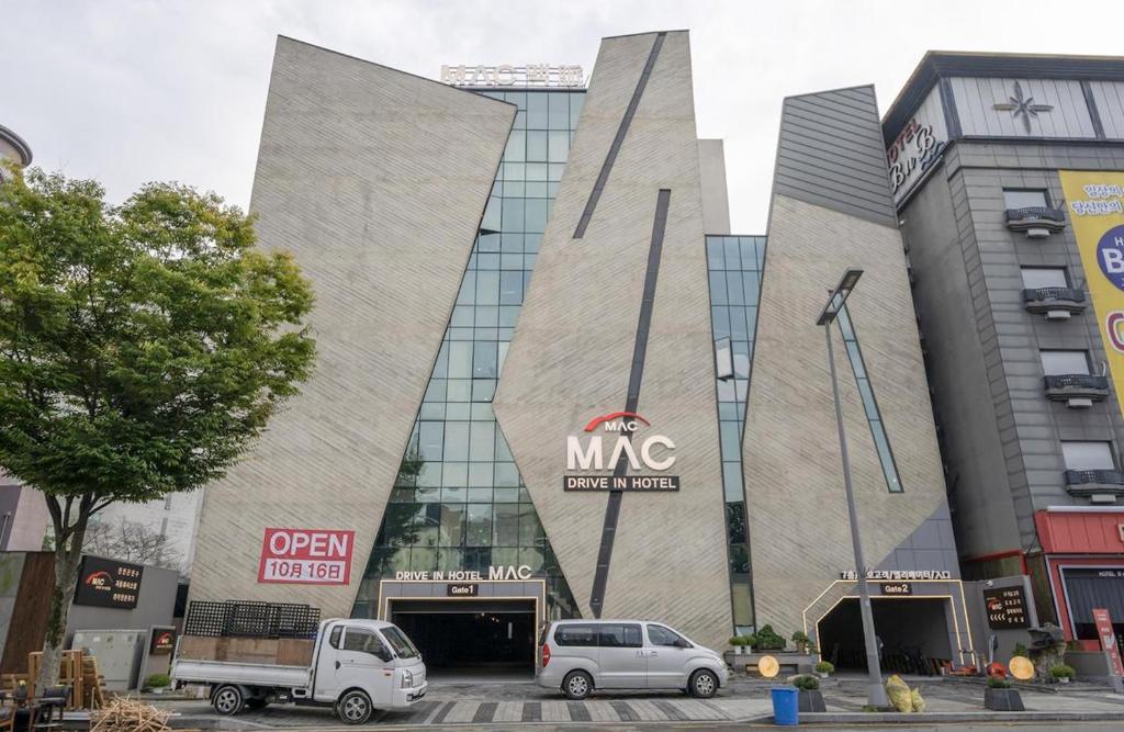 a large building with cars parked in front of it at Daejeon Yuseong MAC Hotel in Yusŏng