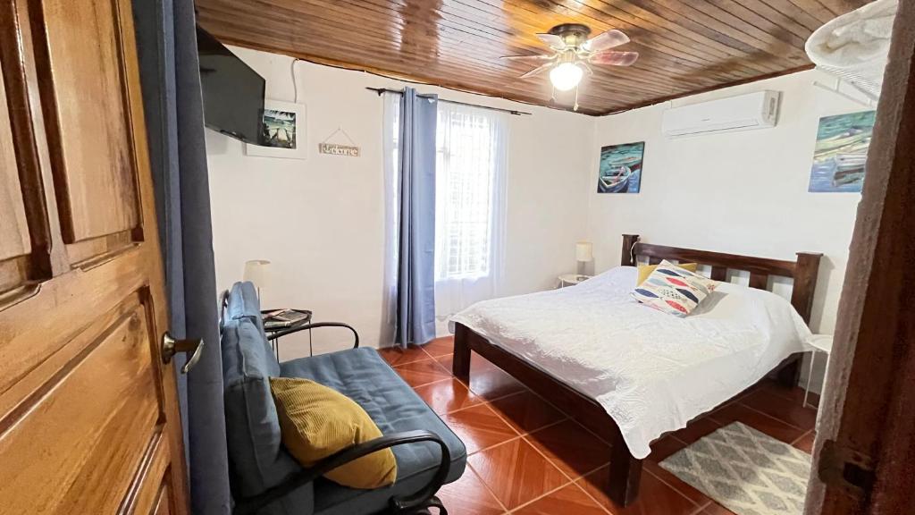 a bedroom with a bed and a chair in a room at Casa Pochote, Cobano in Cóbano