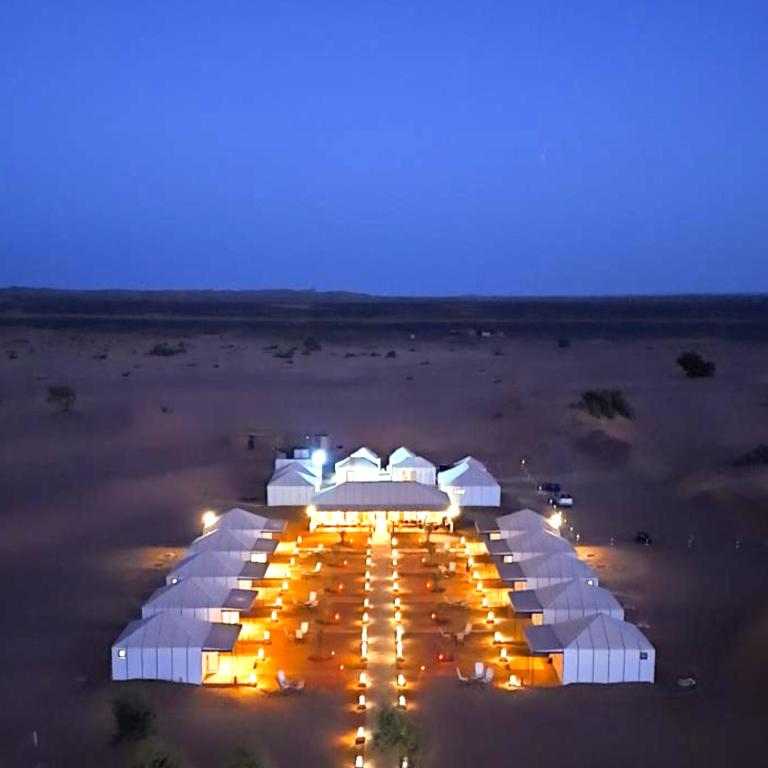 a group of white tents on a beach at night at Best Classic Sahara Experiences in Merzouga