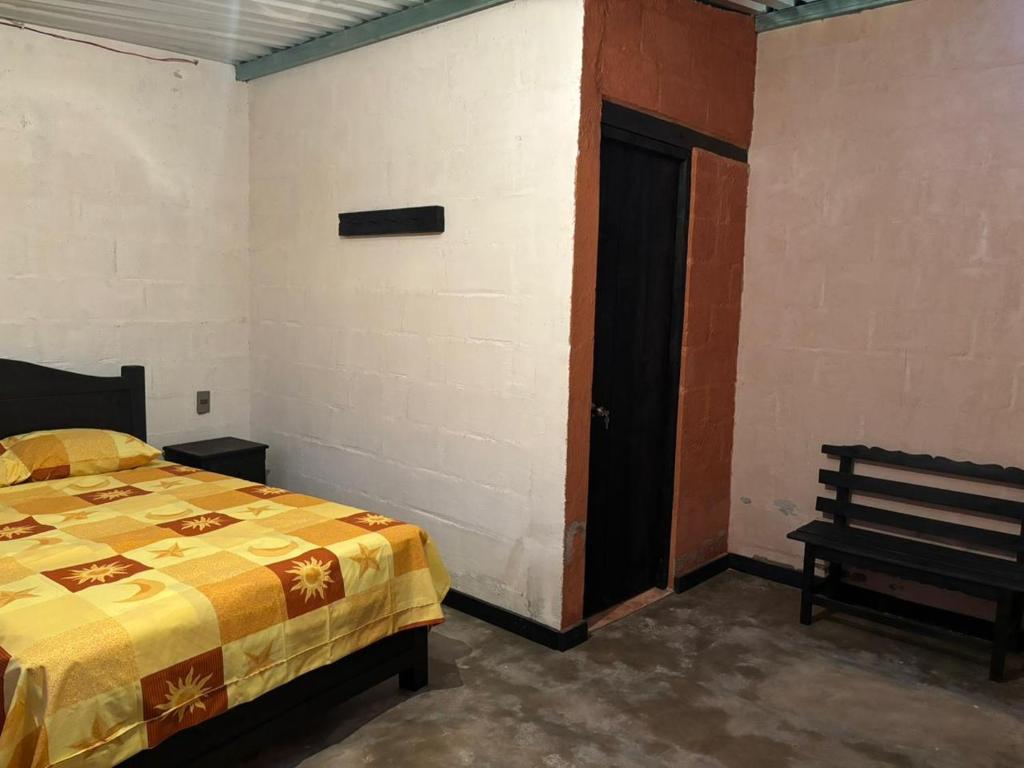 a bedroom with a bed and a bench in it at Villa Xanvil in Zinacantán