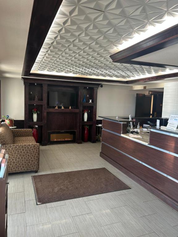 a lobby with a waiting area with a couch and a tv at Home Suites in Thief River Falls