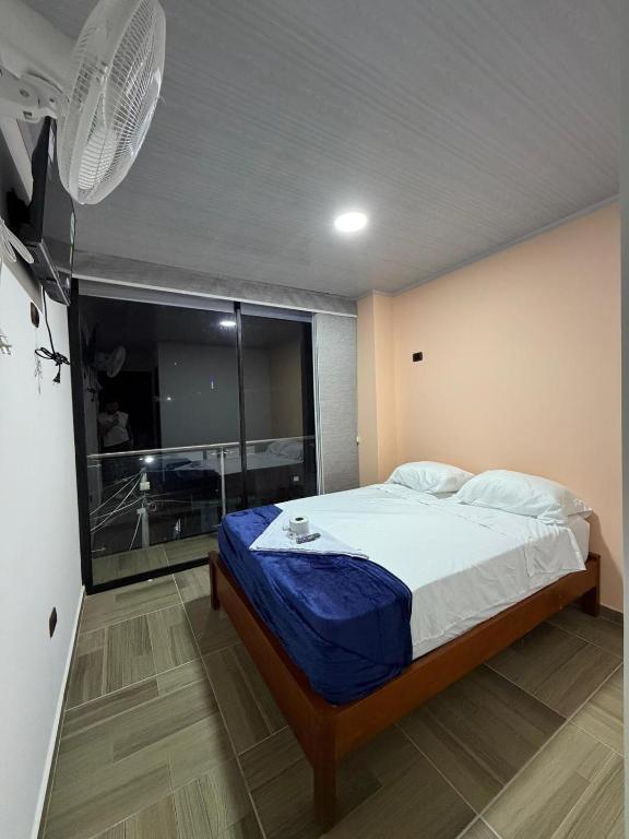 ein Schlafzimmer mit einem Bett und einem großen Fenster in der Unterkunft Hotel Lancan - Pauna, Boyacá in Pauna