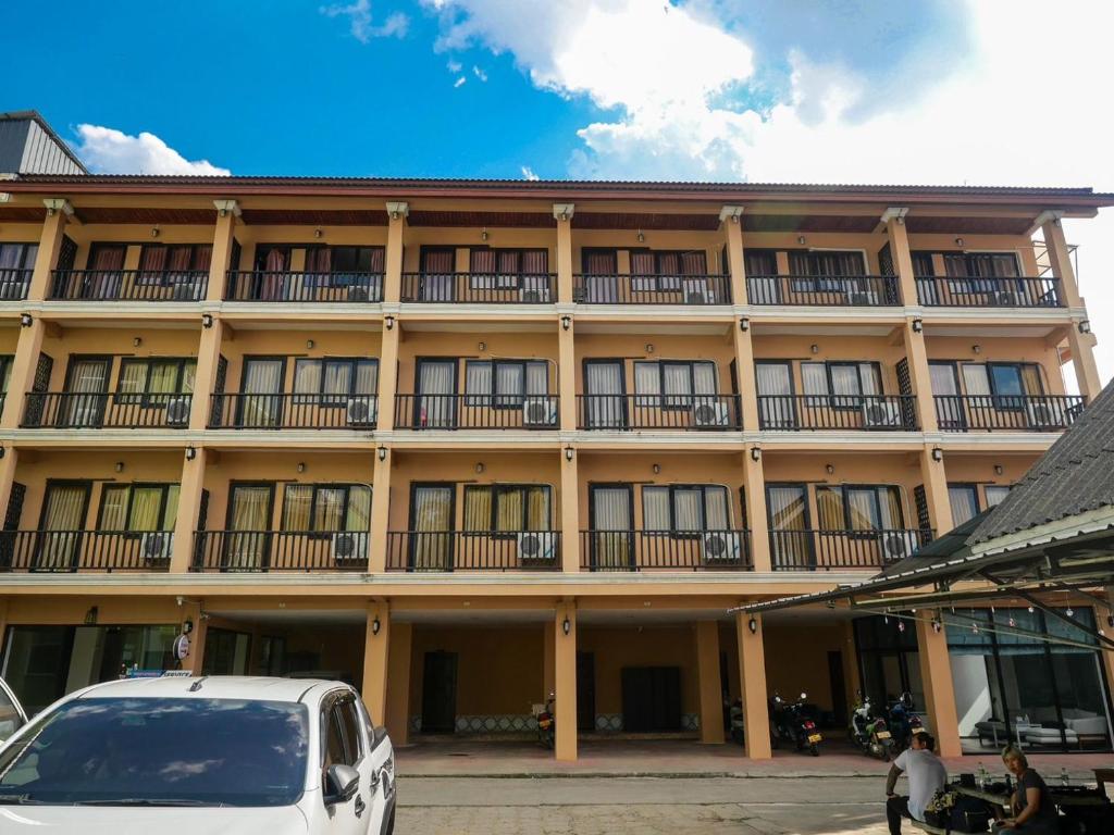 a building with a car parked in front of it at Riverside Houayxay Hotel in Ban Houayxay