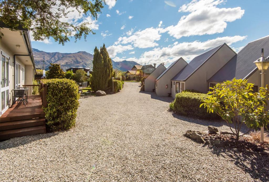 a gravel driveway in a home with mountains in the background at Manuka Crescent Motel in Wanaka