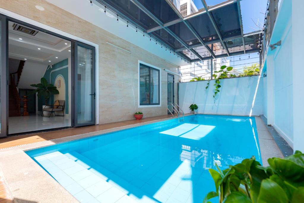 an indoor swimming pool with blue water in a house at Villa B2-11 Long Cung in Vung Tau