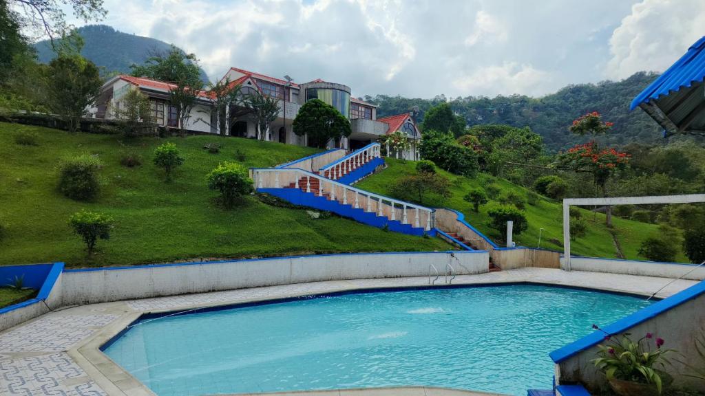 a large swimming pool in front of a house at Finca Casa Real la Vega in La Vega