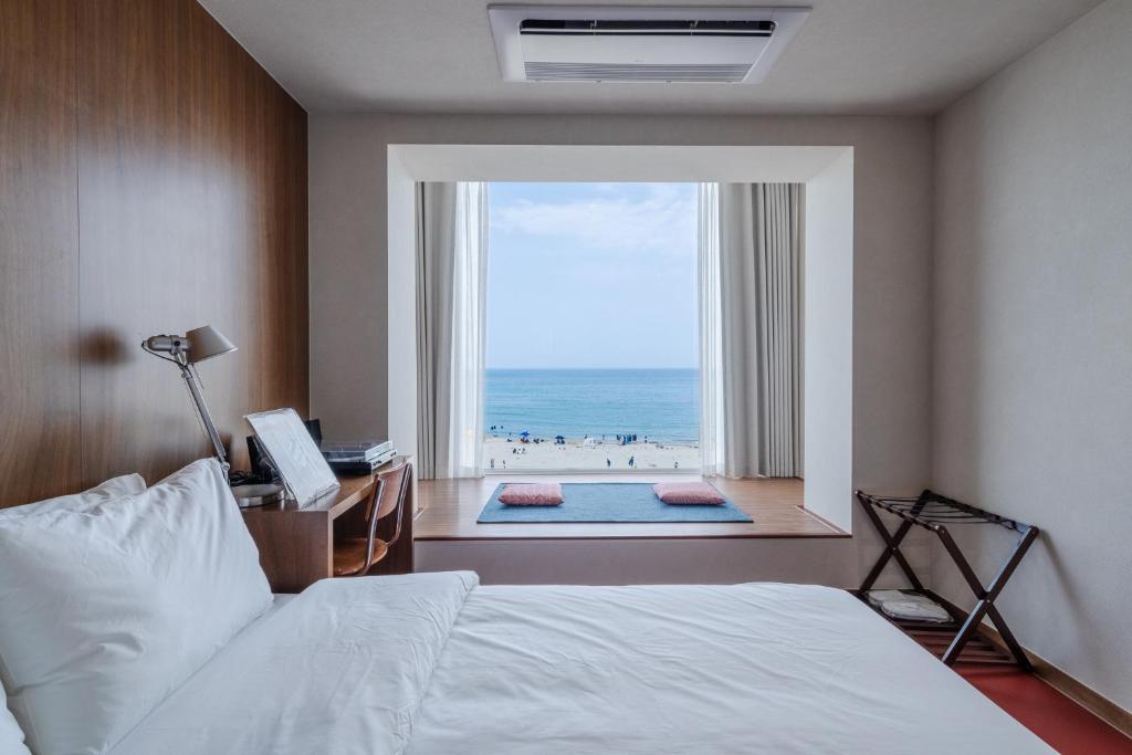 a bedroom with a bed and a view of the ocean at Cabinet 캐비넷 양양 in Yangyang