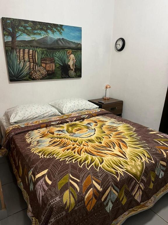 a bedroom with a bed with a painting on the wall at Hospedaje Samao in Santa María del Oro