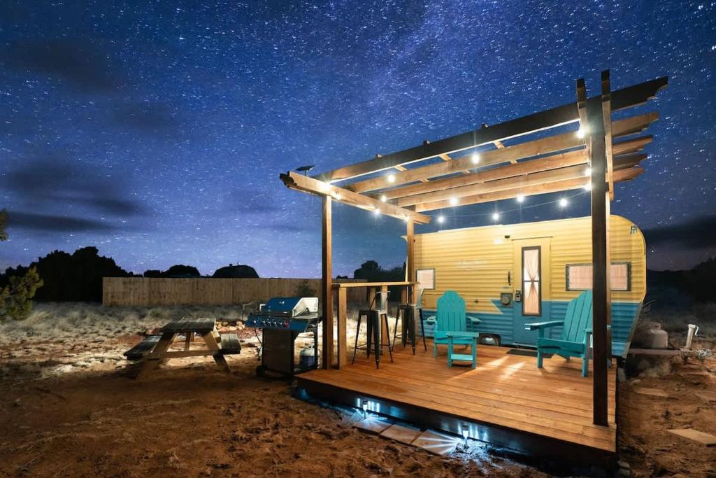 a small cabin with a deck at night at Grand Canyon Stargazing Camper in Williams
