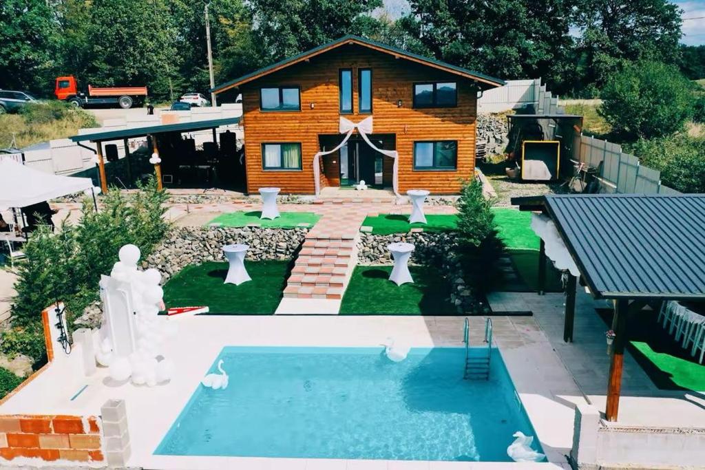 a house with a swimming pool in front of a house at Cabana Athos in Zalău