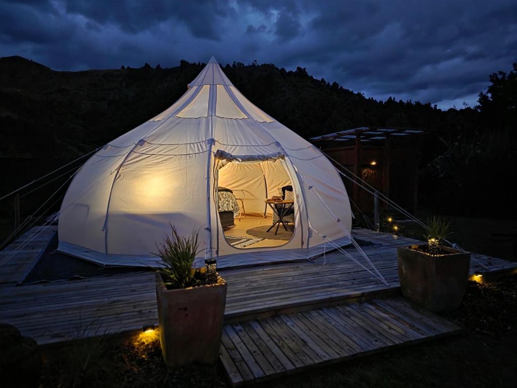 a white tent sitting on a deck at night at Blue Aster Retreat in Mokau