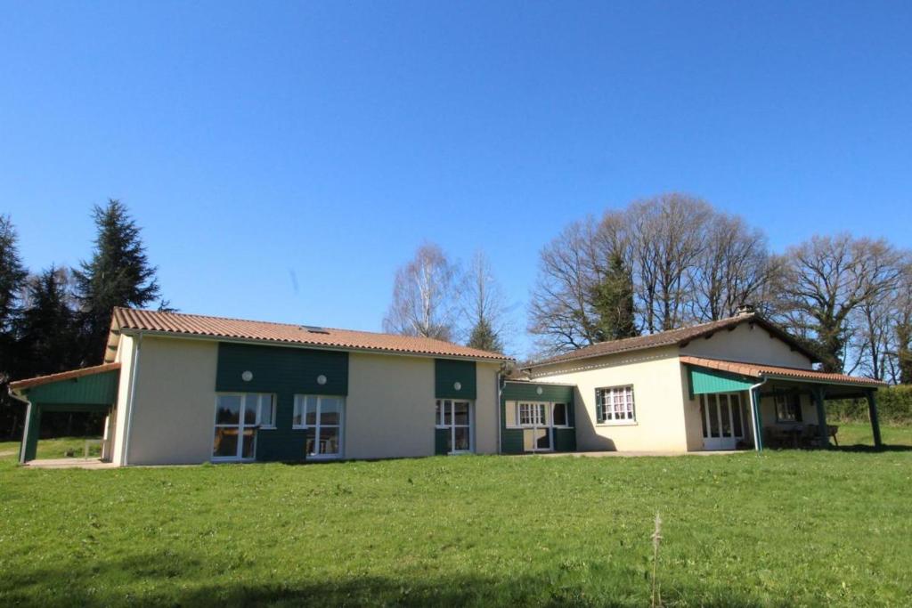 a house with a green field in front of it at La vauloube in Châteauponsac