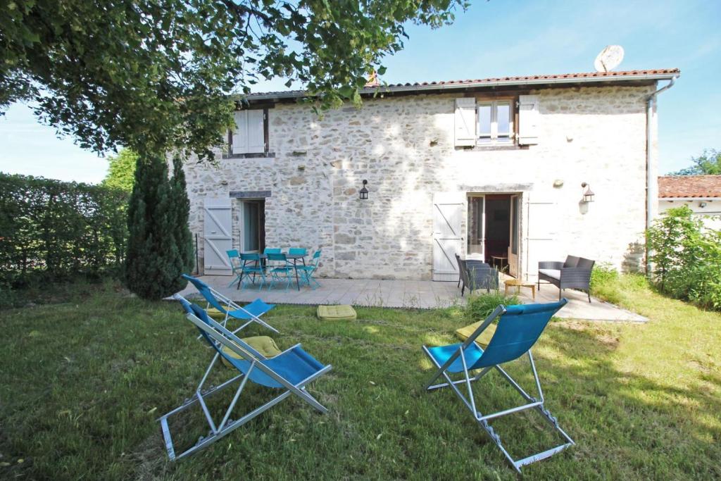 a group of chairs sitting in the grass in front of a building at Le borland in Nantiat