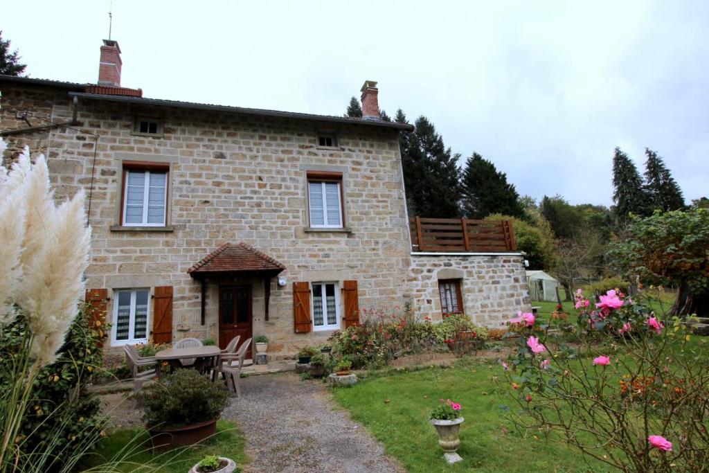 a stone house with a garden in front of it at Négrignas in Augne