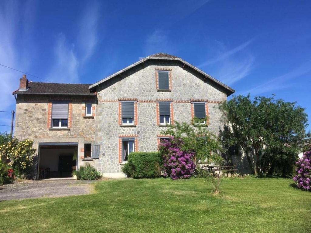 a large stone house with a yard at Serre in Augne