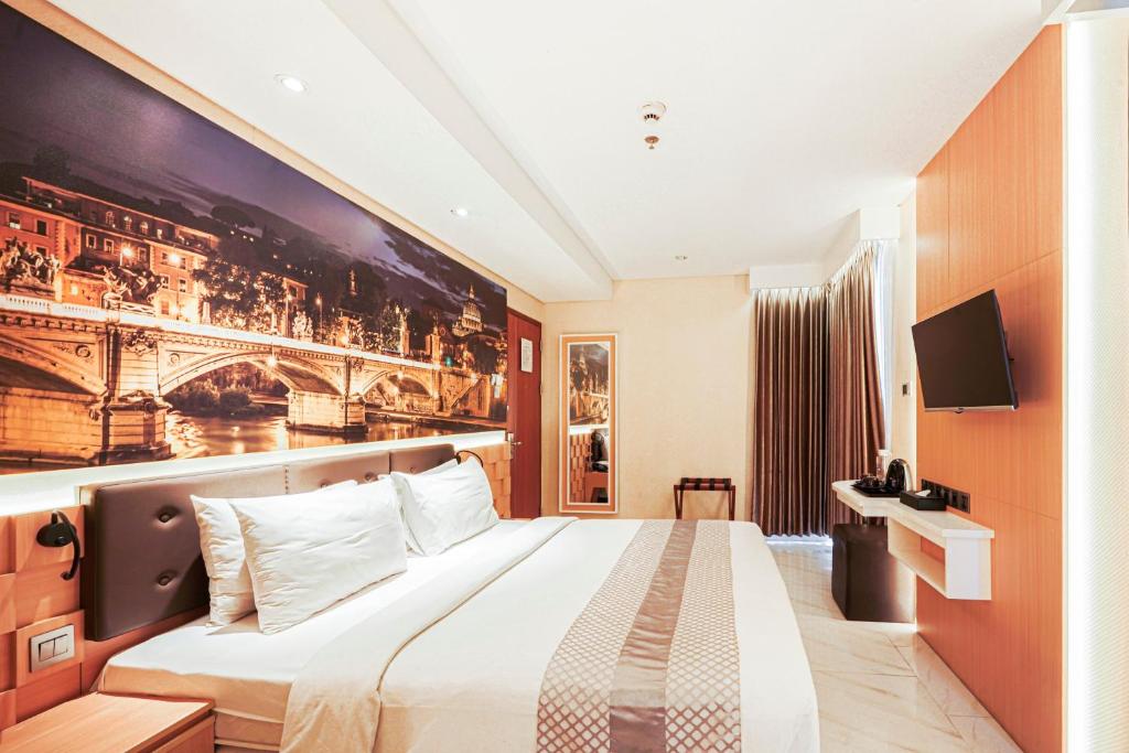 a hotel room with a bed and a painting on the wall at Sunerra Express Grand Viveana Bandung in Bandung