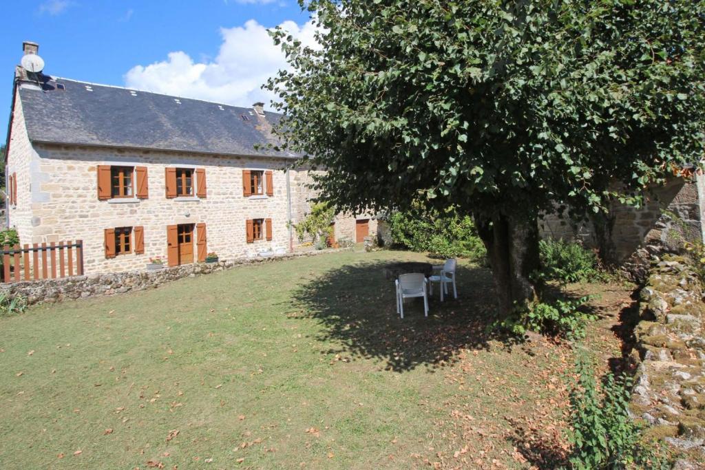 ein altes Steinhaus mit einem Baum davor in der Unterkunft Vichez in Beaumont