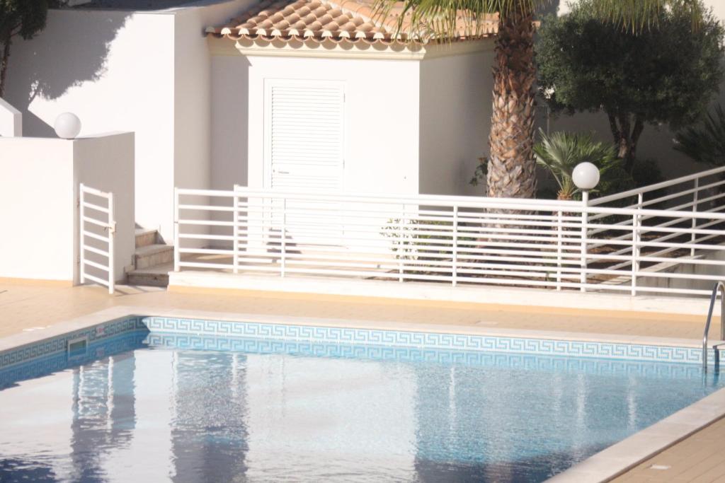 una piscina en una casa con una palmera en Albufeira Lovely new Apartment W/ Pool, en Albufeira